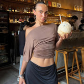 A close-up of the slanted shoulder neckline and ruched texture on the top.